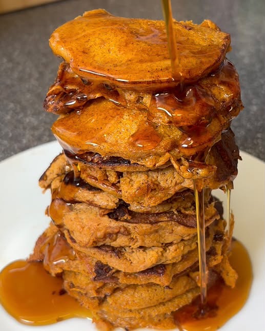 Tall stack of sweet potato pancakes with syrup