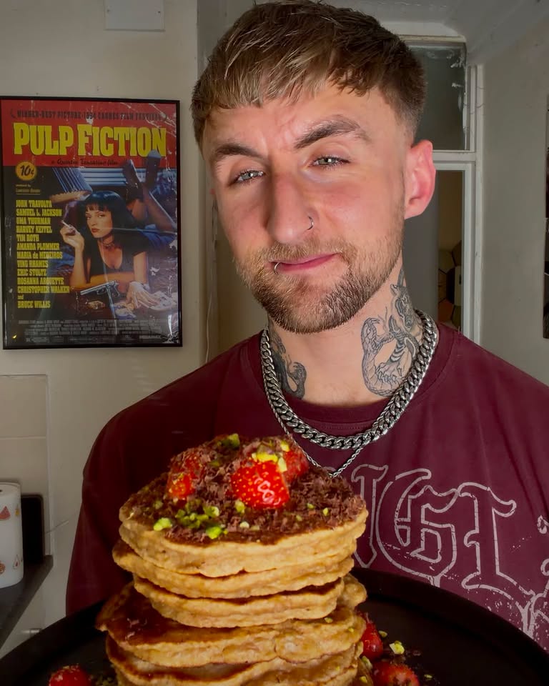 Max holding a stack of pancakes topped with strawberries